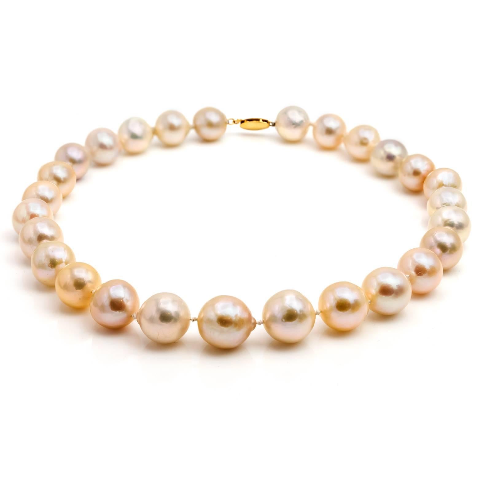 27 gorgeous fresh water pearls slightly taper from larger ones in the middle to smaller in the back. These white pearls have a light peachy-pink and silvery color to them with a 14K yellow gold clasp.  Absolutely stunning and add glamour to