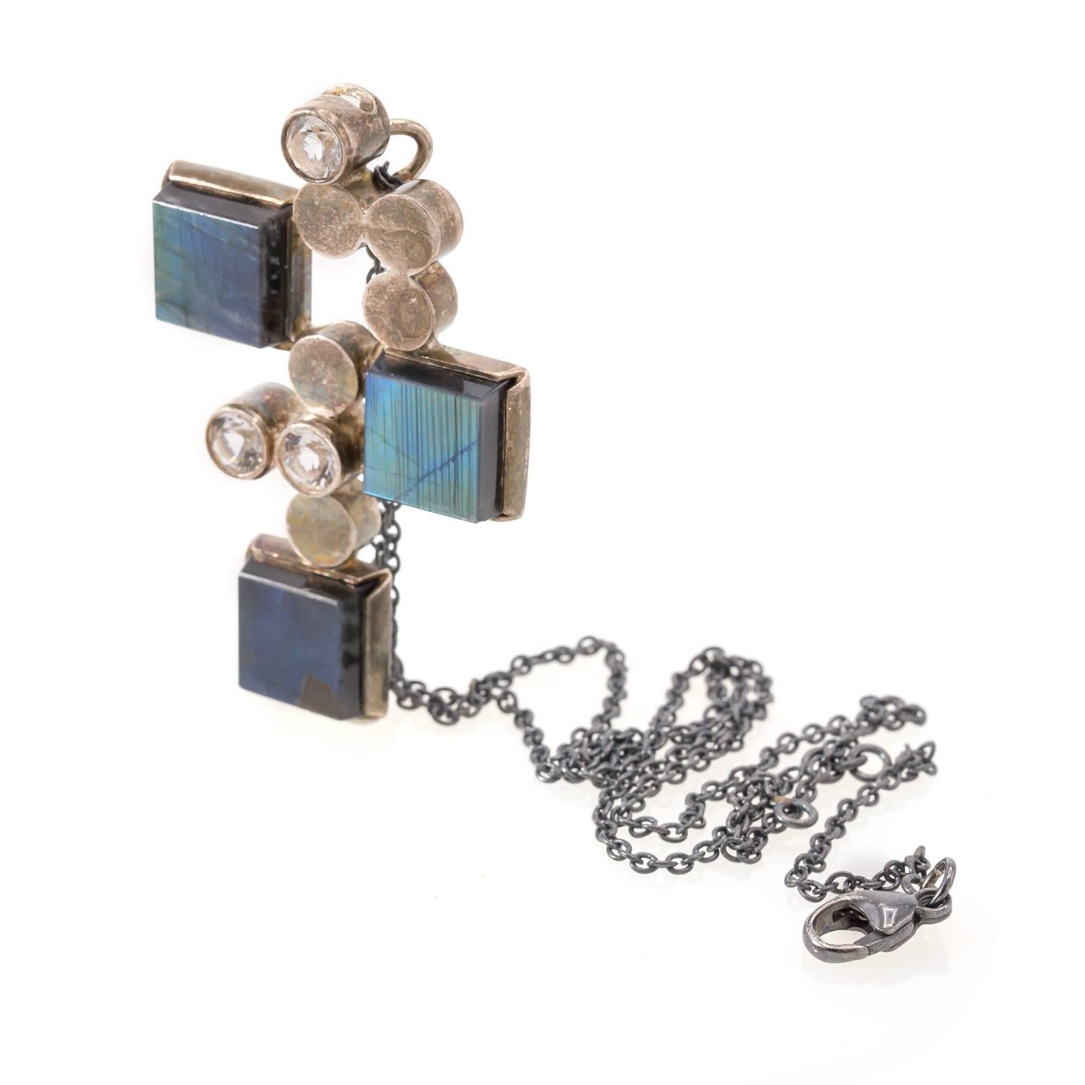 Modern from the 1940's, this square labradorite and round white crystal necklace pendant mirrors a magnificent amulet. Mesmerizing reflections of light and labradoressence shine in linear fashions while the blues and greens glow like fingerprints