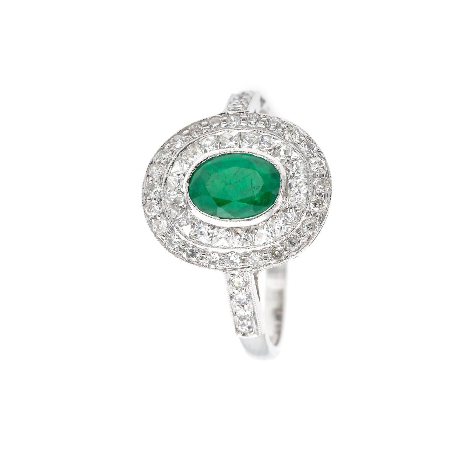 This stunning and sparkling emerald and diamond ring glows from across the room. Circa 1935 made of 18K white gold the emerald is approx 0.6 carats and the total weight for the diamonds are approximately 0.9 carats. Size 7.25 and may be sized.