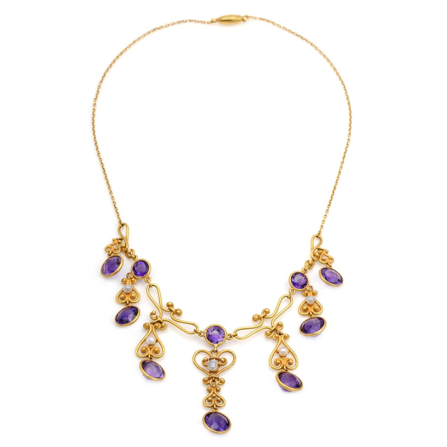 10 round amethysts dangle in spiraling 14K yellow gold with 5 fresh water pearl accents. This substantial negligee sparkles with a great weight of gold giving it the perfect shine and elegance fit for a queen. 