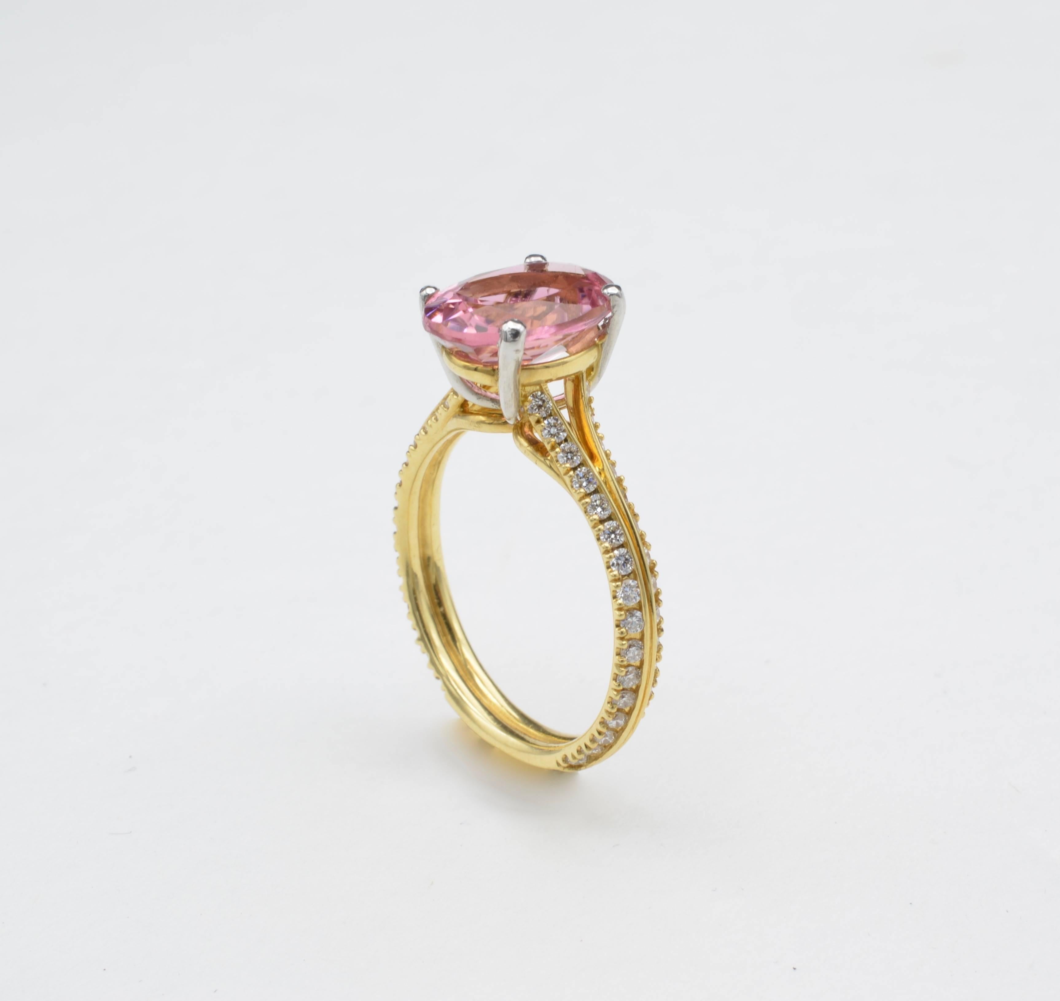 Simple, colorful pink oval tourmaline set in platinum prongs weight approximately 2.80cts  and diamond set on the yellow gold band divided in two branch when coming onto the tourmaline setting. 64 diamond for 0.32 cts
The size of the ring is 7.75