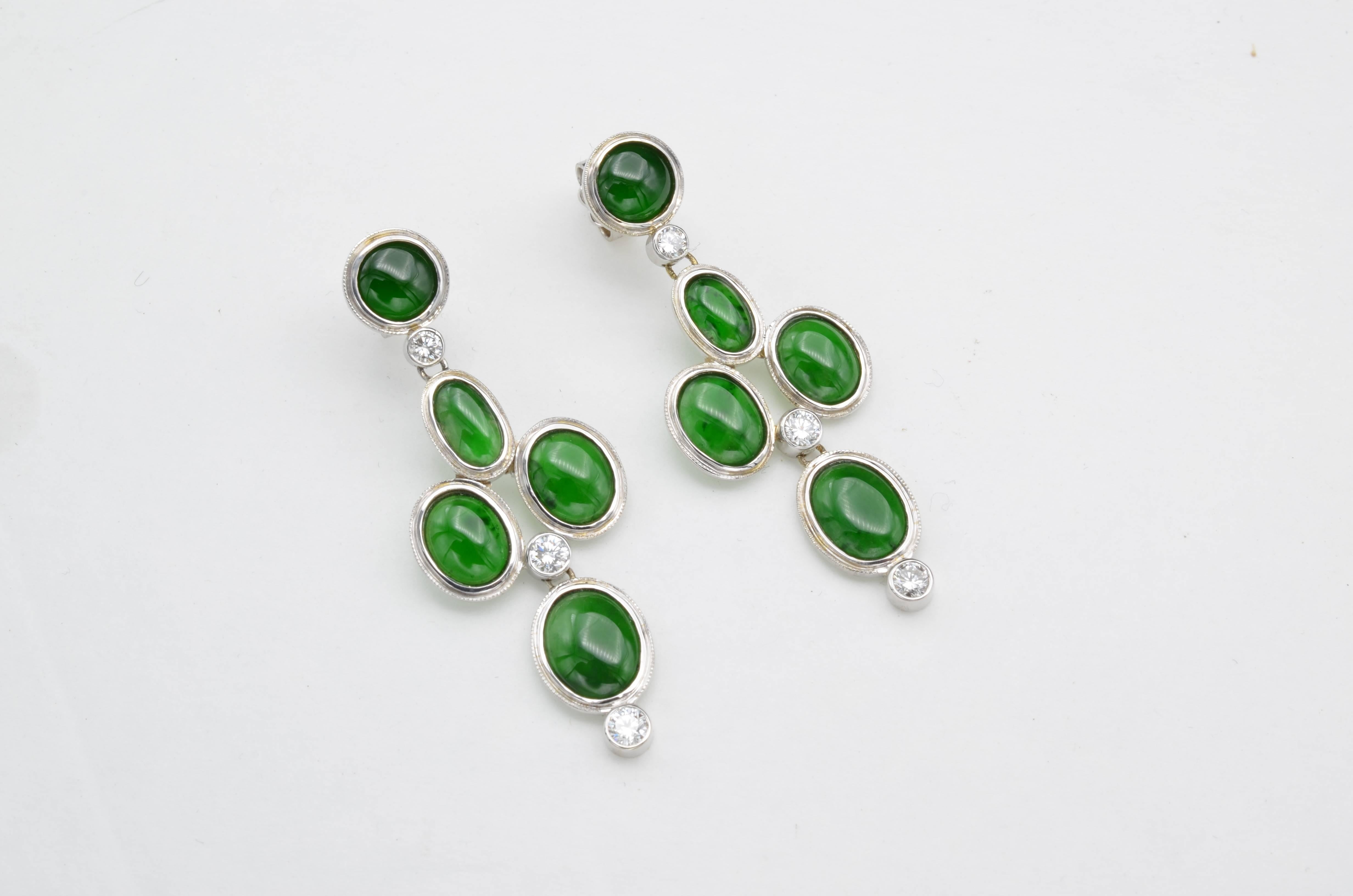 The high quality Jadeite equals 9.91 carats total weight and the round diamond total carat weight is 0.52 carats. Often revered above diamonds, these deep green jadeite earrings are especially sought after in China. The rounds and ovals create a