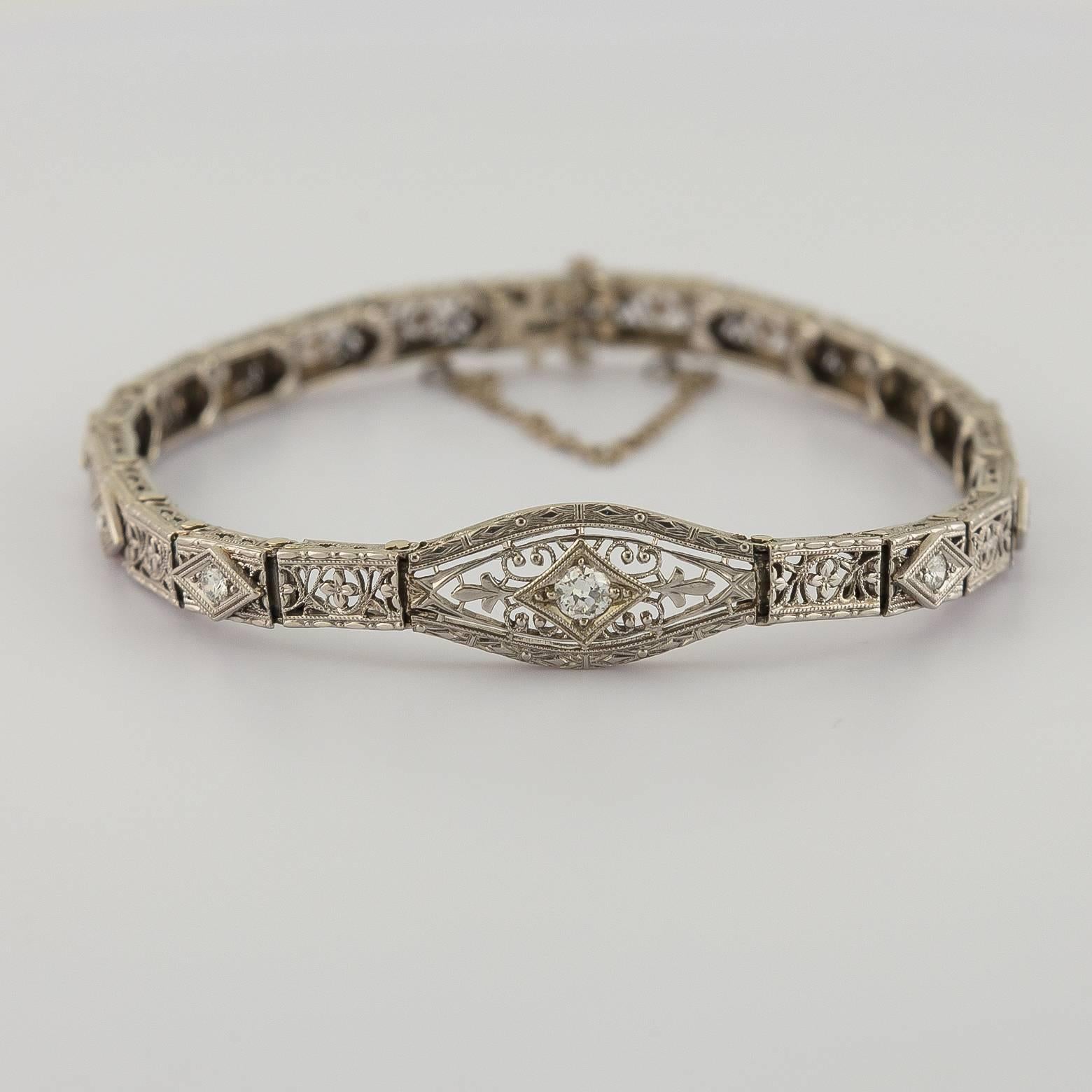 This exquisite diamond bracelet is delicate and finely engraved. Each interlocking 'link' is set with a round diamond and a larger accent diamond in the center.