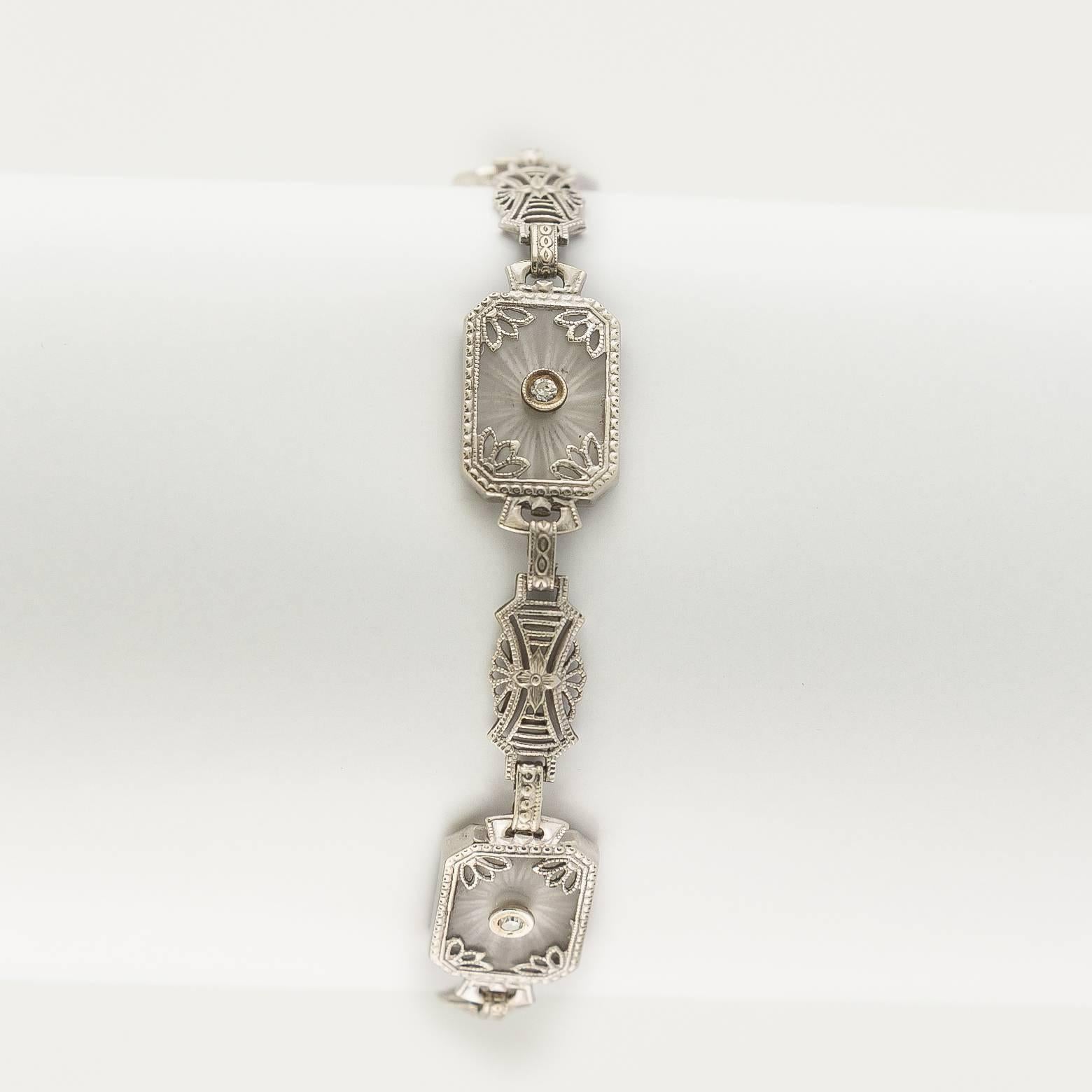 This stunning bracelet is reminiscent of the Roaring 20's. The classic style incorporates diamonds, white gold and clear crystal that is etched with a motif that looks like the rays of the sun. The delicate filigree gently displays the bursts of sun