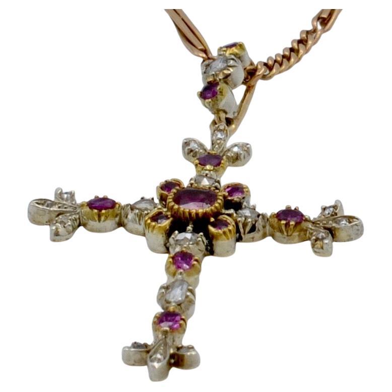 Esta cruz victoriana está bellamente adornada con diamantes (0,28 ct tw aprox.) y rubíes (0,38 ct tw aprox.). Está perfectamente equilibrada con ciruelas de diamantes en cada extremo, así como con una bala incrustada de piedras para añadir una