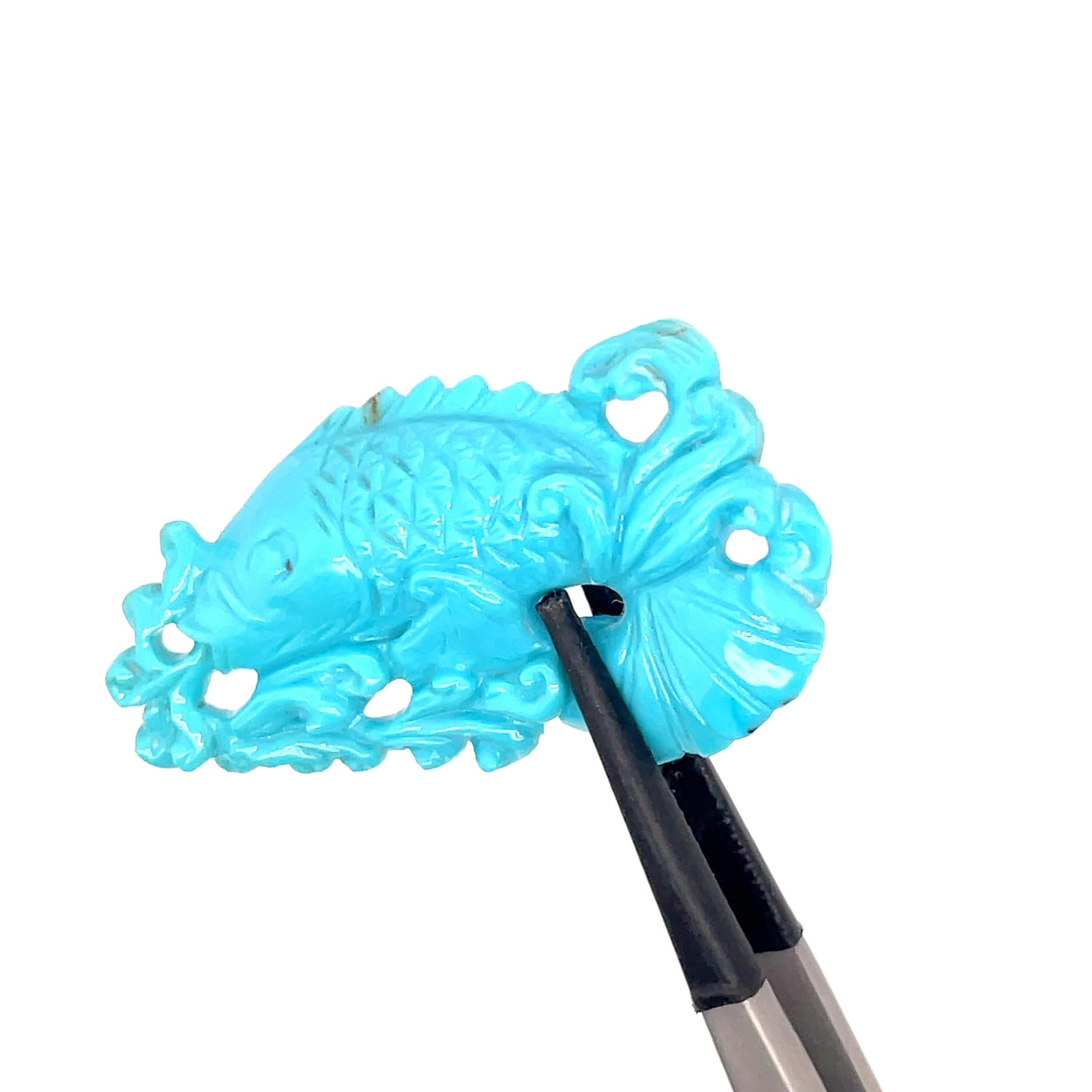 This stunning turquoise carving features a gracefully detailed carp, symbolizing strength, prosperity, and perseverance in many cultures. 

Weighing 25.04 carats, this unique piece is sourced from the rich turquoise mines of Tibet, known for