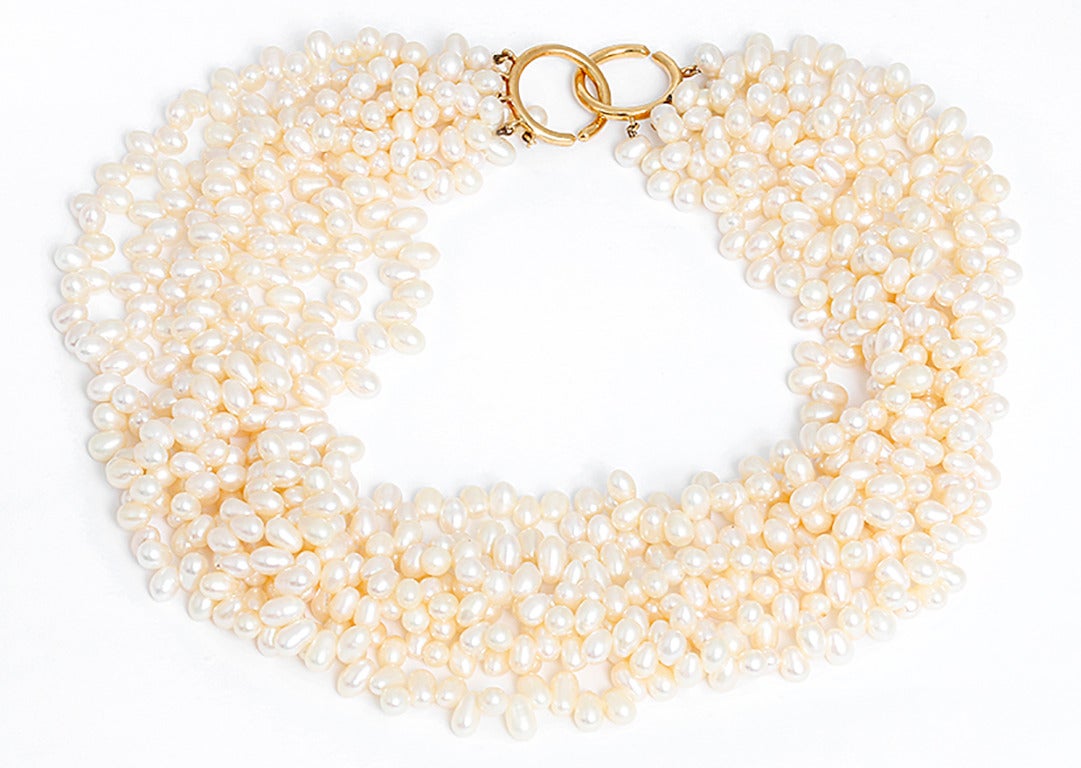 This necklace features eight-strands of freshwater cultured pearls with an 18k yellow gold clasp. Pearls measure apx. 4.5-5 mm. The necklace measures apx. 16-inches in length and weighs 178.1 grams. It is signed Paloma Picasso, 1983, Tiffany & Co.,