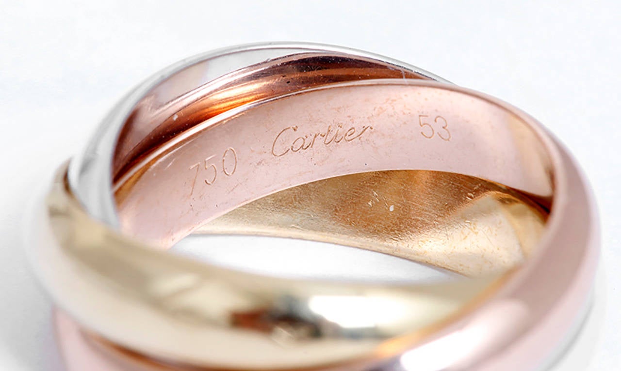 This Cartier Trinity ring features 18k white, yellow, and pink gold. Three symbolic colors: pink for love, yellow for fidelity and white for friendship. The ring is stamped Cartier, 53, 750, 1997, LV750L. Each band is apx. 3.5 mm wide. Ring is size