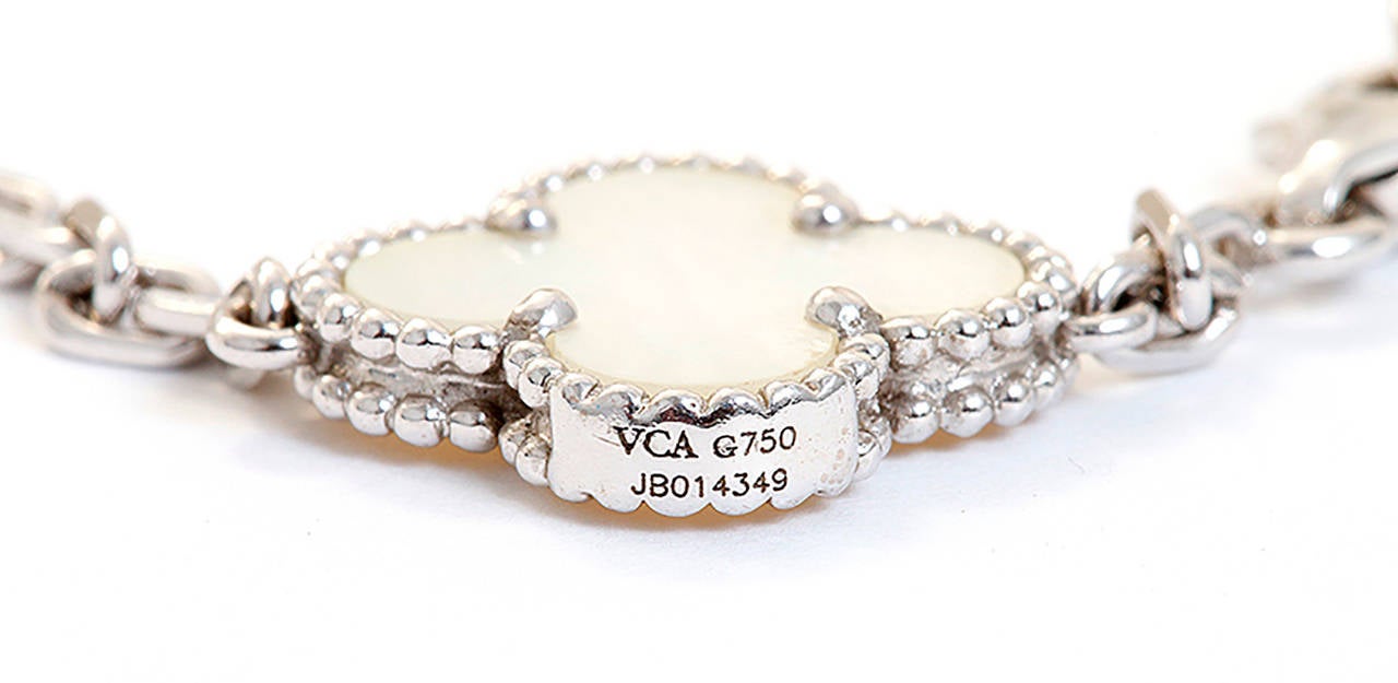 This Van Cleef & Arpels bracelet is part of the Vintage Alhambra collection. It features 5 iconic motifs in mother-of-pearl set in 18k white gold.  It is stamped VCA, G750, JB014349. It measures apx. 7-inches in length and weighs 11.6 grams. Van