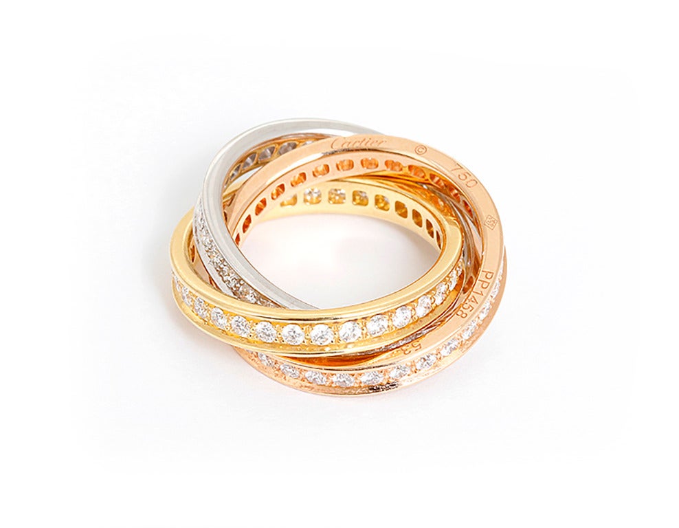 This Cartier Trinity ring features diamonds set in 18k white, yellow, and pink gold bands. Three symbolic colors: pink for love, yellow for fidelity and white for friendship. The ring is stamped Cartier, 750, PP1458, 53. Total weight is 14.6 grams.
