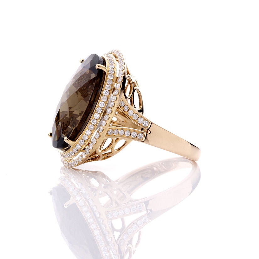 This ring features a 15.29 carat smoky quartz bordered by  0.88 carats of diamonds set in 18k rose gold. The ring measures apx. 3/4-inch in width and apx. 1-inch in length. 

Total weight is 9.9 grams. Size 6-1/2.