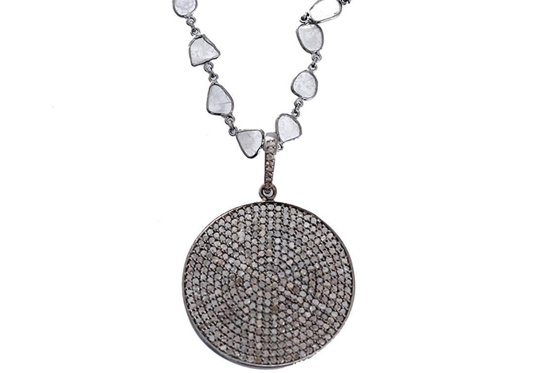 This amazing necklace features a circle diamond pendant on a sliced diamond and oxidized sterling silver chain. Necklace measures apx. 23-inches in length with apx. 2-7/8 pendant drop. Total weight is 17.2 grams.