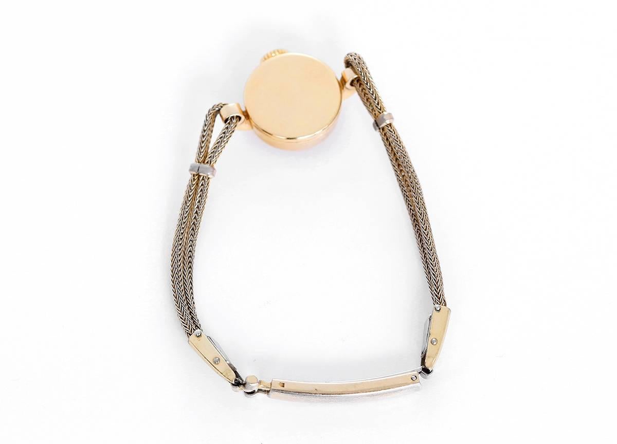 Manual winding. 14k yellow gold case (15mm diameter). Silvered dial with gold stick markers. Gold plated rope-style bracelet (will fit apx. 5-3/4 in. wrist). Pre-owned, vintage, with custom box.