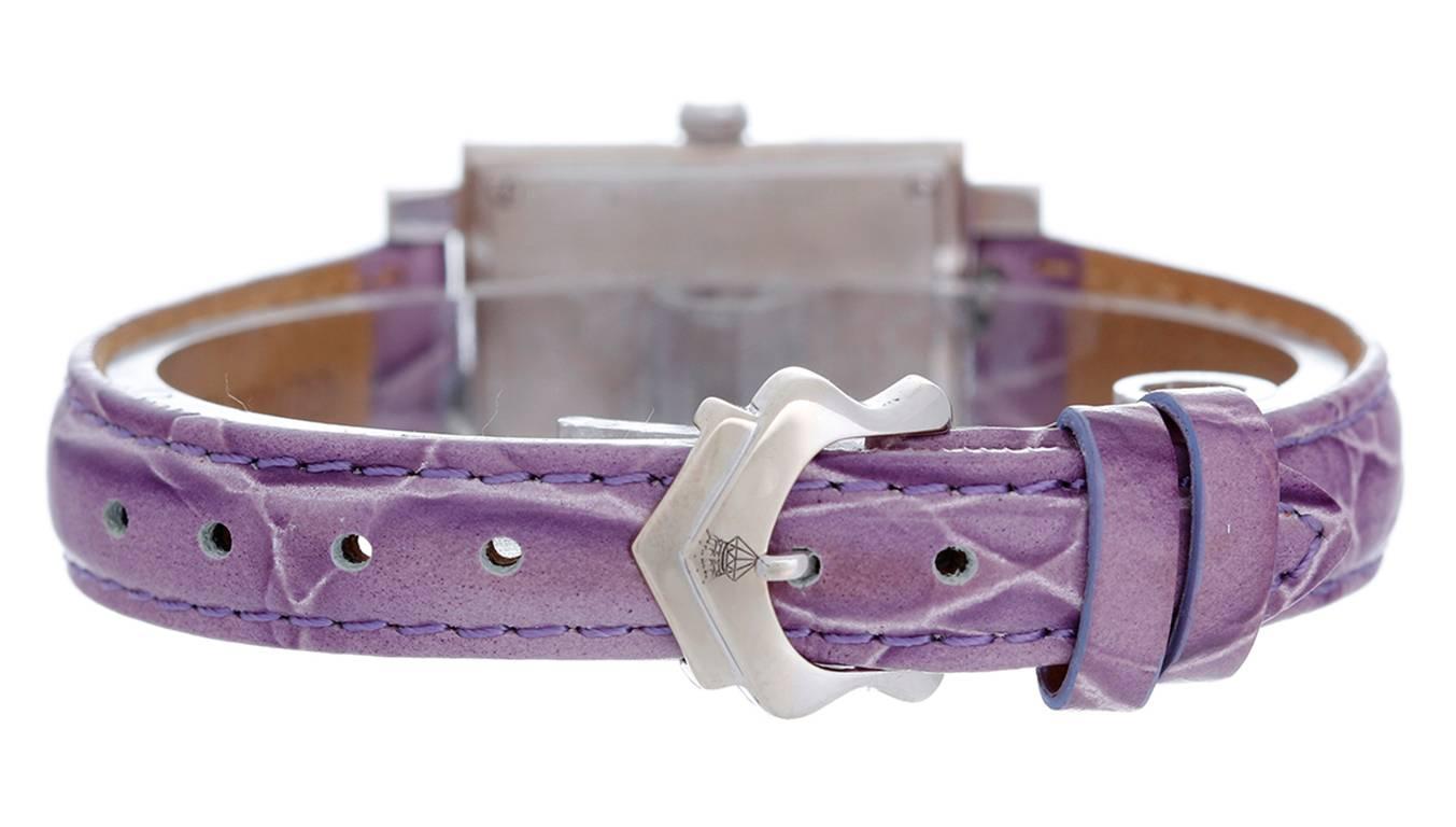 Quartz. 18k white gold case with white diamond and lavender sapphire accents (30mm x 45mm). Silvered diamond dial with Arabic numeral 6 & 12. Lavender alligator strap band with 18k white gold Chatila buckle. Pre-owned with custom box.