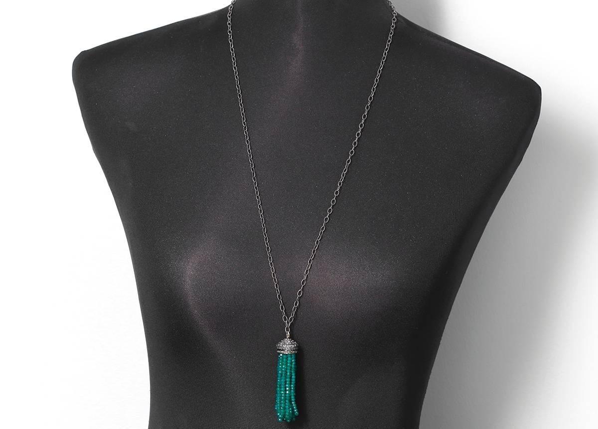 This necklace features a diamond and silver tassel with several emerald bead strands. Sterling silver chain measures apx. 32-inches in length and tassel measures apx. 2-1/2 inches in length. Total weight is 29.7 grams.