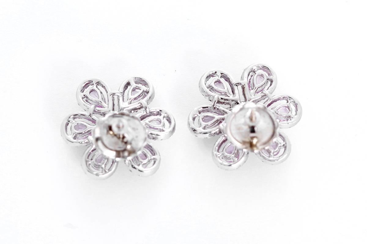 These stunning earrings feature 1.09 carats of diamonds, 2.69 ctw. of rubies, and 2.64 carats of pink sapphires set in 18k white gold with post backs. Earrings measure apx. 3/4-inch in diameter. Total weight is 9.0 grams.