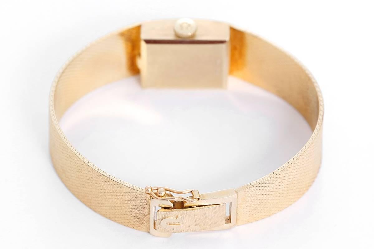 Quartz. 14k yellow gold case (15mm x 18mm). Textured gold dial with stick markers. 14k yellow gold integrated mesh Omega bracelet with safety clasp (will fit apx. 5-1/2 inch wrist). Pre-owned with custom box.