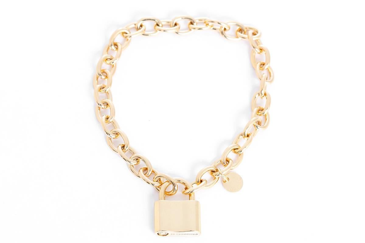 This amazing Tiffany & Co. chain link bracelet features a padlock charm in 18k yellow gold. Bracelet measures apx. 7-inches in length. Padlock charm measures apx. 3/4-inch in length and apx. 9/16-inch in width. Hallmarked, 