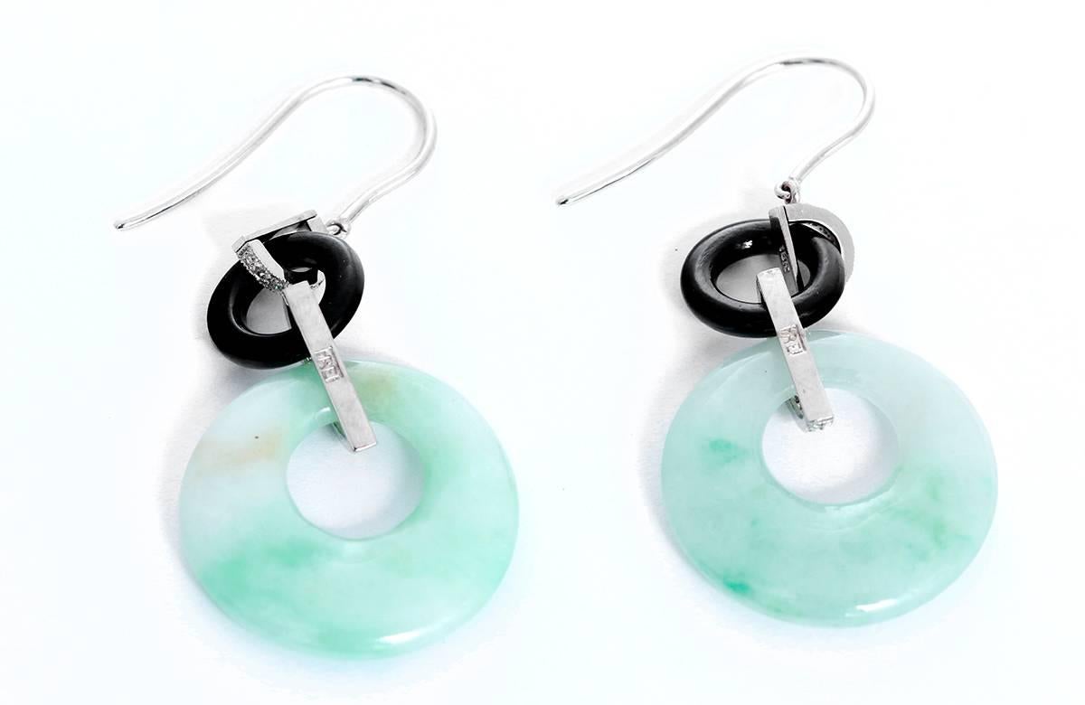 These earrings feature jadeite jade bi and carved black onyx with apx. 0.20 ct. diamonds (Avg Color: G-H-I, Avg Clarity: SI) set in 18k white gold. Earrings measure apx. 1-7/8 inches x 13/16 inch. Total weight is 7.40 grams. Marked, Frei 18K.