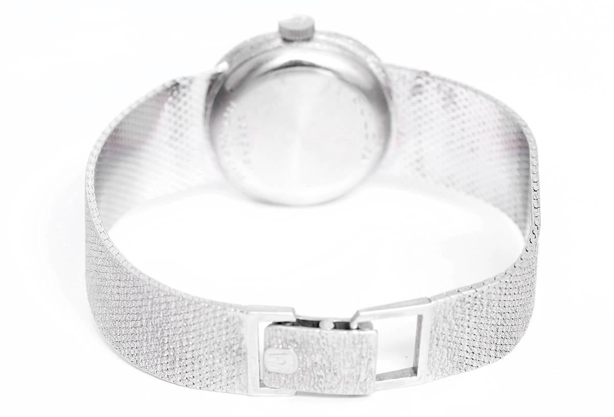  Quartz. Stippled 14k white gold (19mm diameter). Grey with luminous hour markers. 14K white gold mesh bracelet with deployant clasp. Pre-owned with custom box.