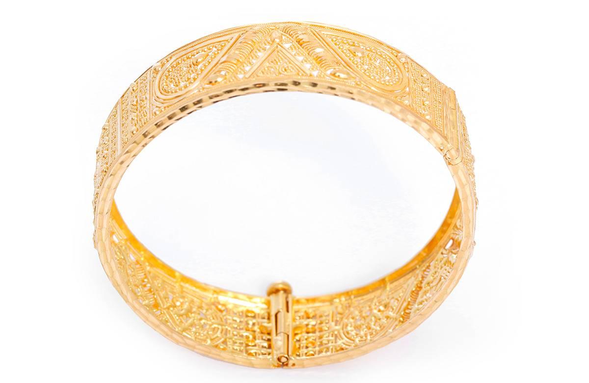 This bohemian style bracelet features an intricate ornate design with matte and shine finish in 22k yellow gold. Bracelet measures apx. 5/8-inch in width and fits up to apx. a 7-inch wrist. Total weight is 36.4 grams.