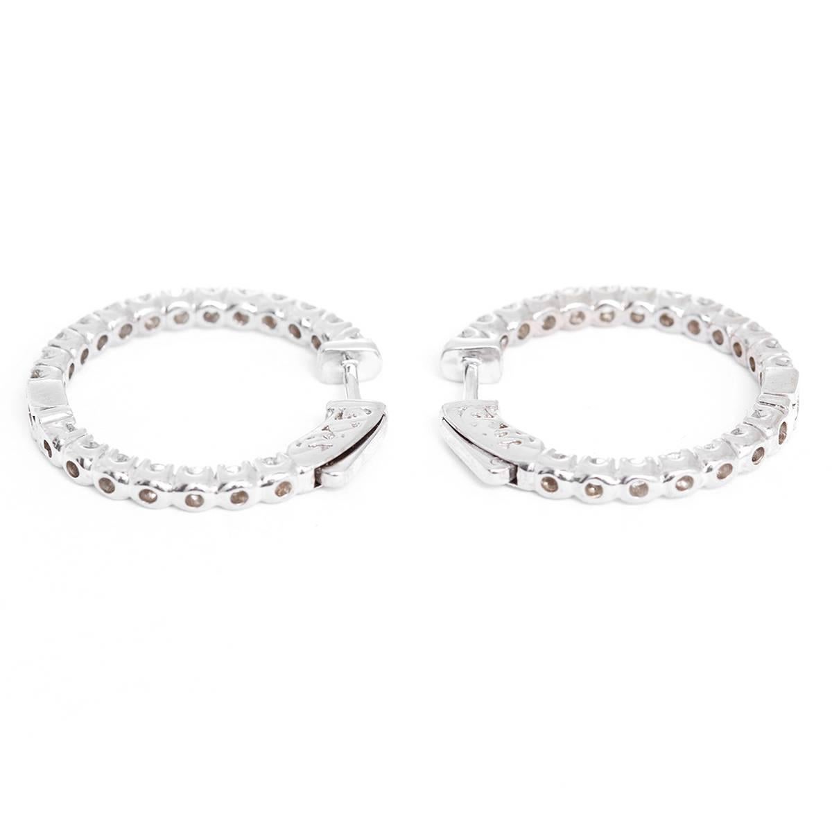 These inside-out style hoop earrings feature 1.86 carats of SI1-S2-clarity and H-I-color diamonds set in 14k white gold. Earrings measure apx. 1- inch in diameter.  Total weight is 7.4 grams.