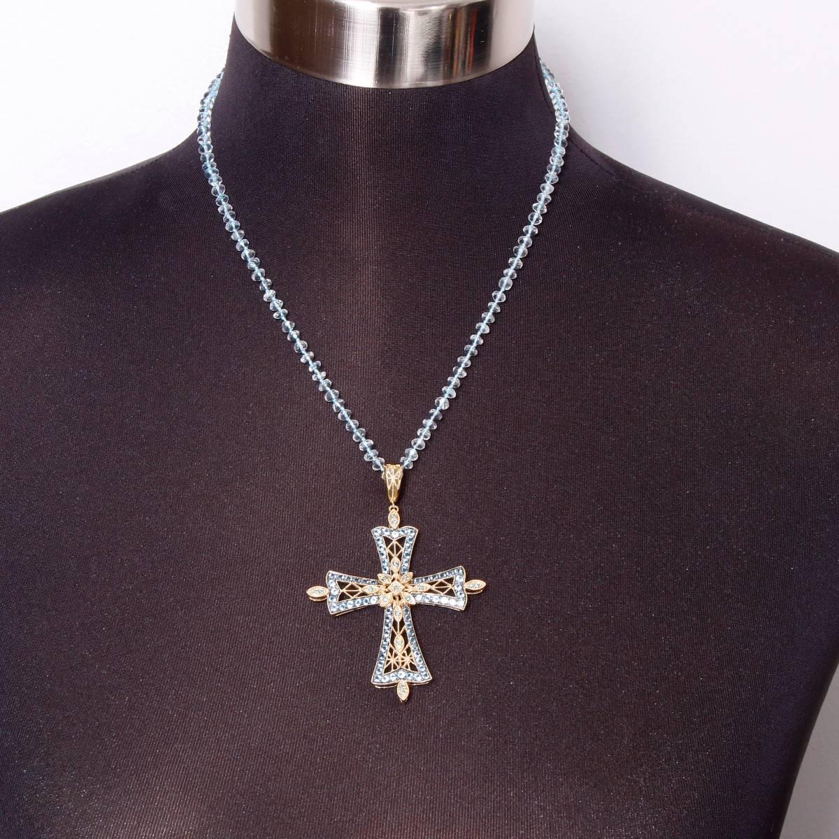 This necklace designed by Dallas Prince Designs features a cross pendant with a hinged removable bail. Pendant has 18 blue diamonds (0.36 ct.) in the center and at cross tips and features 70 blue topaz stones (3.50 ct.) outlining the cross set in