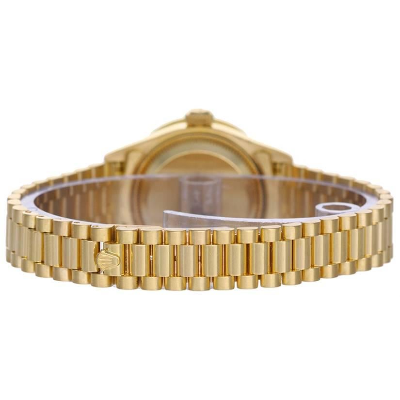 Rolex Ladies President 18k Yellow Gold Diamond Watch -  Automatic winding, 29 jewels, Quickset date, sapphire crystal. 	18k yellow gold case with smooth bezel (26mm diameter) (26mm diameter). 	Factory Tiger's Eye dial. 18k yellow gold bracelet.