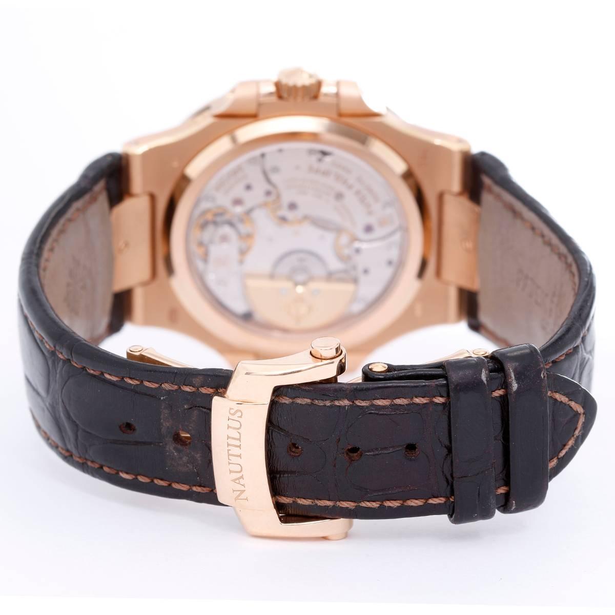Patek Philippe & Co. Nautilus 18K Rose Gold Watch 5712R
-  Automatic winding. 18K Rose Gold ( 43 mm x 38 mm ). Black dial with Date, Moon-phase, Small second, Power Reserve sub dials. Brown leather bracelet with Patek Philippe Nautilus clasp.