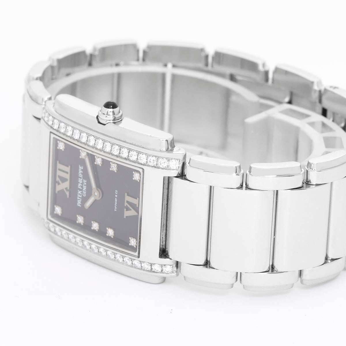 Patek Philippe Twenty-4 Ladies Steel & Diamond Watch 4910/10A -  Quartz. Stainless steel case; bezel set with 36 diamonds (25mm x 30mm). Black dial with diamond markers and Roman numerals. Stainless steel Patek Philippe bracelet. Pre-owned with