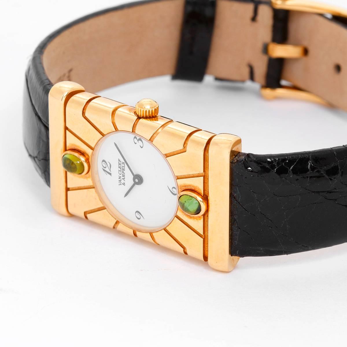 Van Cleef & Arpels Façade 18K Yellow Gold Vintage Watch -  Quartz. 18K Yellow Gold  (22 mm x 33 mm) with green tourmaline on bezel. White dial with  Arabic numerals. Black strap bracelet. Pre-owned with original Van Cleef & Arpels box.