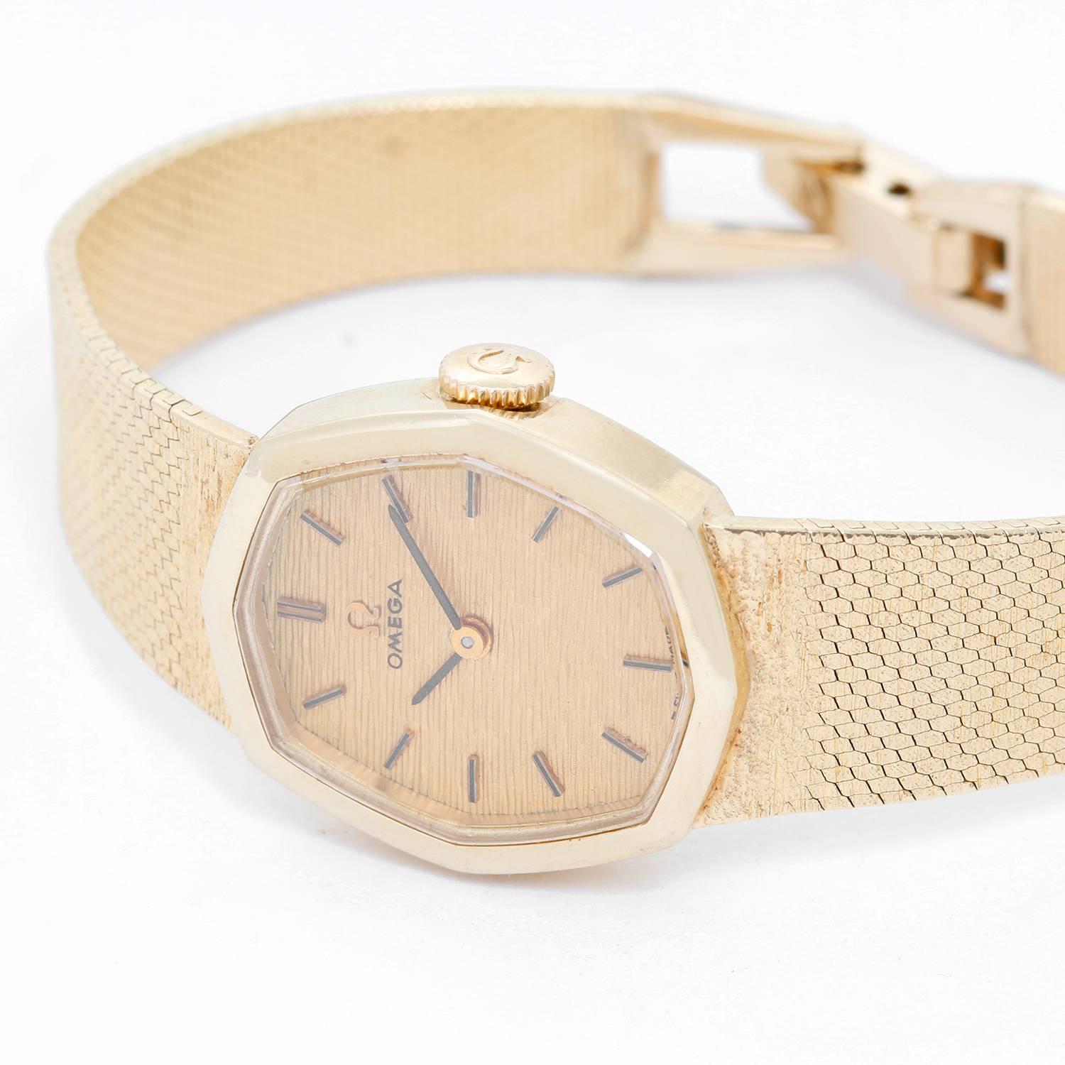 Vintage Omega 14K Yellow Gold Ladies Watch -  Quartz. 14K Yellow Gold Octagonal shaped ( 21 mm ). Textured Champagne dial with stick hour markers. 14K Yellow Gold smooth textured mesh band with no stretch on it. Hinged clasp. Will fit a 5.5"