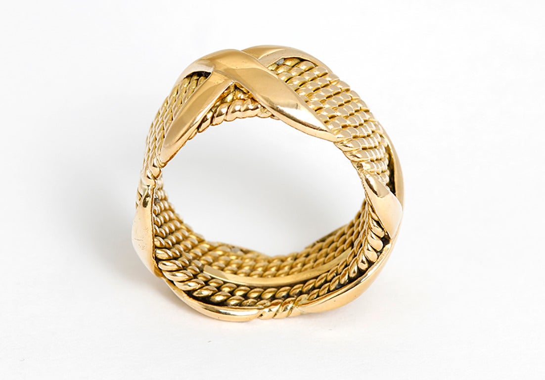 This Tiffany & Co. Jean Schlumberger ring features a rope and 'X' design in 18k yellow gold. Stamped Tiffany & Co., Schlumberger, and 750. Band measures apx. 3/8-inch in width.  Total weight is 10.9 grams. Size 5.25.