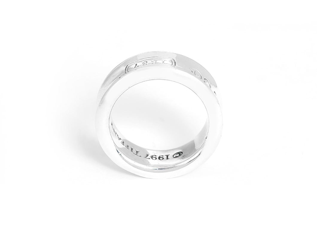 This Tiffany & Co. 1837 sterling silver ring is stamped 1997, Tiffany & Co., and 925. Ring measures apx. 1/4-inch in width. Total weight is 5.3 grams. Size 5.5.