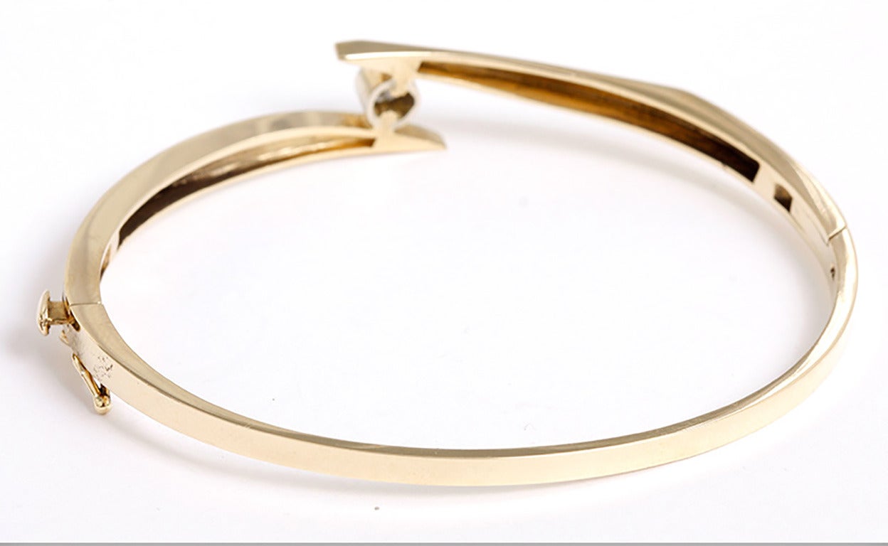 This 14k yellow gold bangle bracelet features a round diamond  apx. .33ct. The bracelet is 3mm at the  narrowest point and 10mm at the widest point where the diamond is mounted. It is slightly oval and measures 2-1/4 in. x 2-1/2 in. in diameter.  