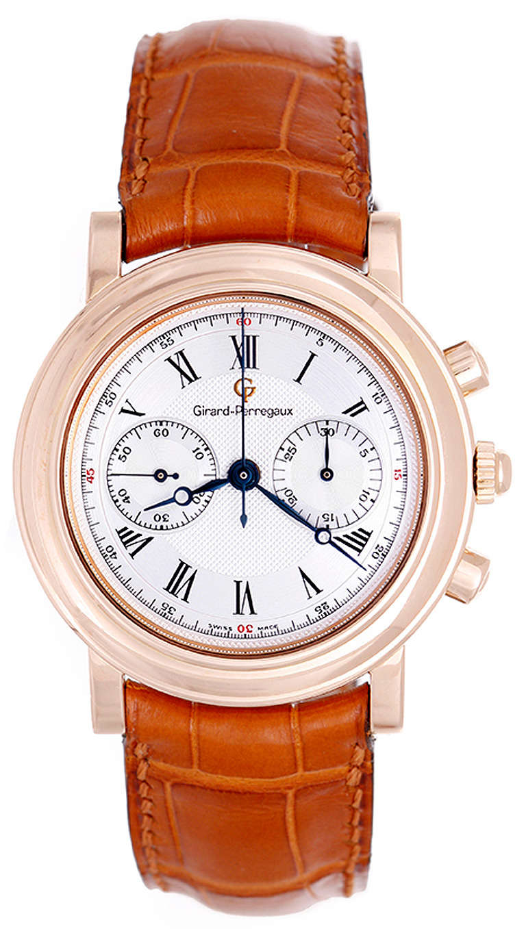 Manual-wind movement. 18k rose gold case, 38mm, with exposition back to view movement. Two-tone silvered dial with guilloche center, black Roman numerals, minute register and subsidiary seconds. Tan Girard-Perregaux strap and 18k rose gold buckle.