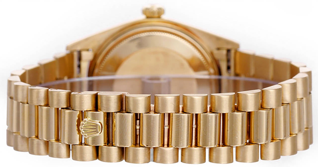 Automatic winding; non-quick-set; acrylic crystal. 18k yellow gold case with fluted bezel (36mm diameter). Champagne dial with raised gold stick markers. 18k yellow gold hidden-clasp President bracelet. Pre-owned with box and books.