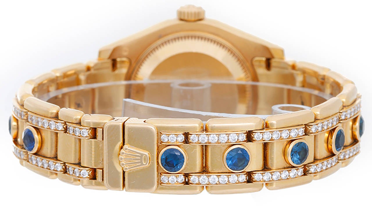 Automatic winding, 31 jewels, Quickset, sapphire crystal. 18k yellow gold case with 32 diamond Rolex bezel (29mm diameter). Rolex factory mother of pearl Myraid dial with 11 sapphire hour markers. 18k yellow gold genuine Rolex Pearlmaster bracelet