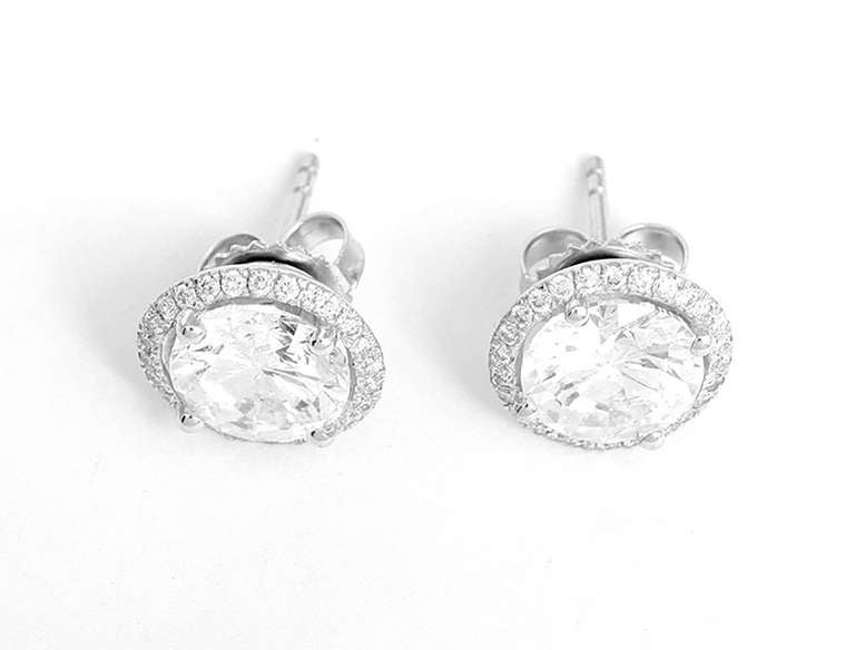 These beautiful 14k round brilliant cut diamond earrings  are fabulous for any occasion!  Each earring features a 2 carat diamond centered by a border of diamonds. They measure apx. 11 mm in diameter with a total weight of 3.2 grams. See additional
