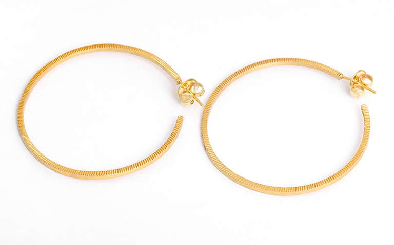 These chic 18k yellow gold Yossi Harari hoop earrings feature  1.25 total carat weight sparkling diamonds. The earrings measure apx. 1-3/4 inches in diameter with a total weight of 13.1 grams.