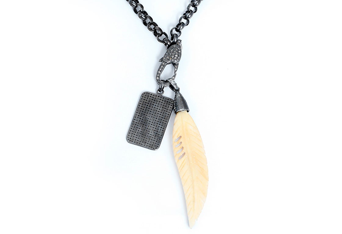 This amazing  necklace features a diamond dog tag pendant with an oxen bone and  diamond feather pendant on an oxidized stainless steel chain. Chain measures apx. 34-inches in length. Total weight is 65.1 grams.
