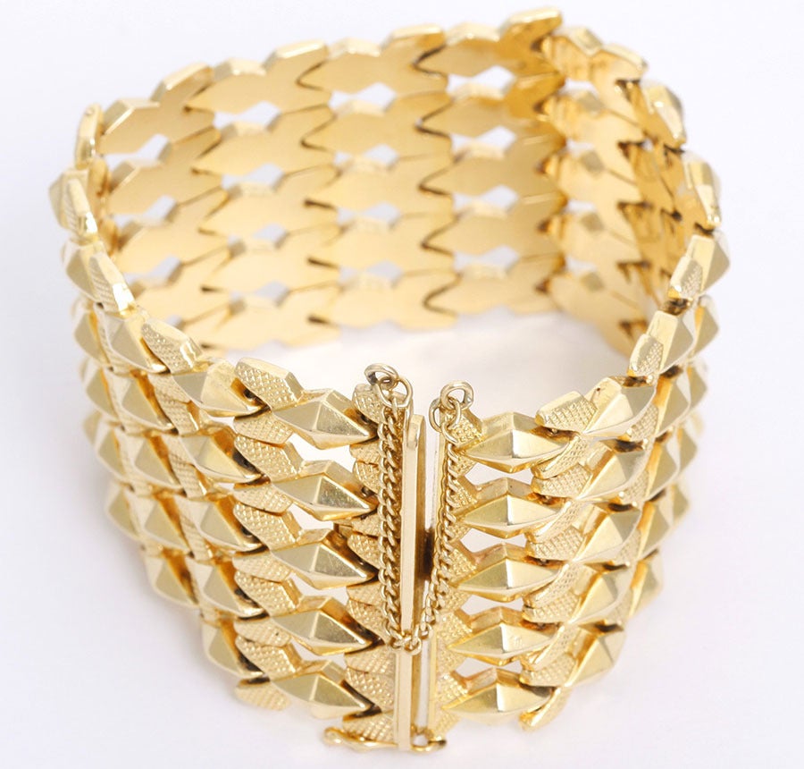 This bracelet is crafted in a combination of heavily textured and brightly polished 18k gold. It measures 8 inches x 2 inches. Gross weight 78.5 grams. Although the links are hollow, the bracelet is still weighty and well balanced.  Very classy look!