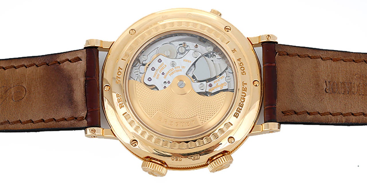 Automatic winding; alarm with power reserve indicator; dual time. 18k yellow gold case with exposition back (39mm diameter). Silver guilloche dial with black Roman numerals; date and subseconds dial at 6 o'clock, alarm time at 3 o'clock, on/off at