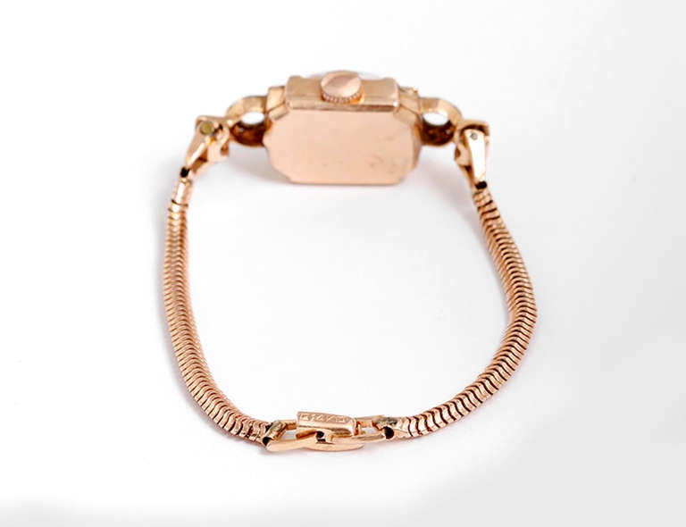 Manual-wind movement. 14k rose gold case with ruby and diamond lugs 13mm x 34mm. Rose-colored dial with Arabic numerals. 14k rose gold rope-style bracelet, will fit approx. 5-1/2-in. wrist.