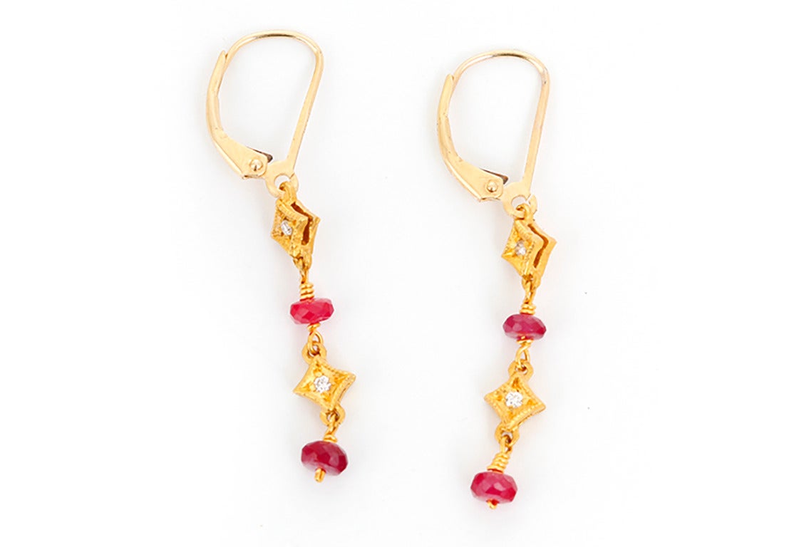 These amazing dangle earrings each feature two rubies and two diamonds in 14k yellow gold. These earrings measure apx. 1-inch in length with a total weight of 2.9 grams. Earrings are perfect for everyday as well as dress!