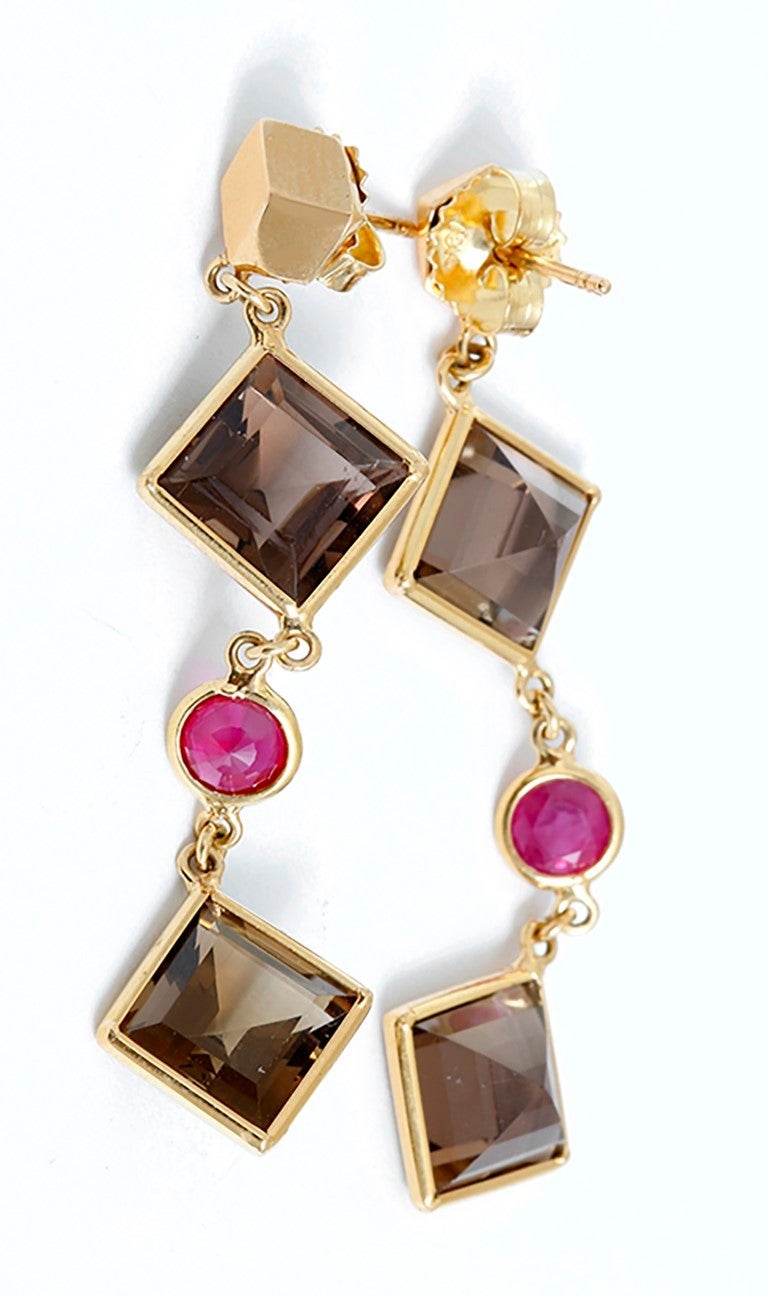 From the Florentine Collection, these earrings feature 10.21 carats of square smoky topaz and 1.01 carats of round rubies set in 18k yellow gold.  Earrings measure apx. 2-inches in length. Total weight is 5.7 grams.