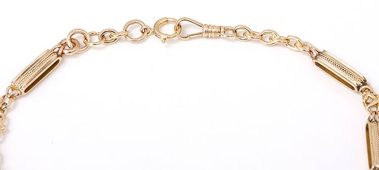This 14k yellow gold pocket watch chain has unusual uniquely twisted links between large 6mm wide links. It measures 15-1/2-inches in length and would be stunning worn as a necklace.