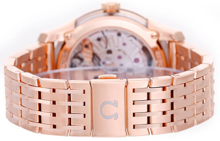 Ref.  431.60.41.21.13.001. Automatic movement. 18k rose gold case with exposition sides and back, 41mm diameter. Brown dial with silvered outer rim, rose gold baton indexes, date at 3 o'clock. 18k rose gold Omega DeVille bracelet. Pre-owned with box