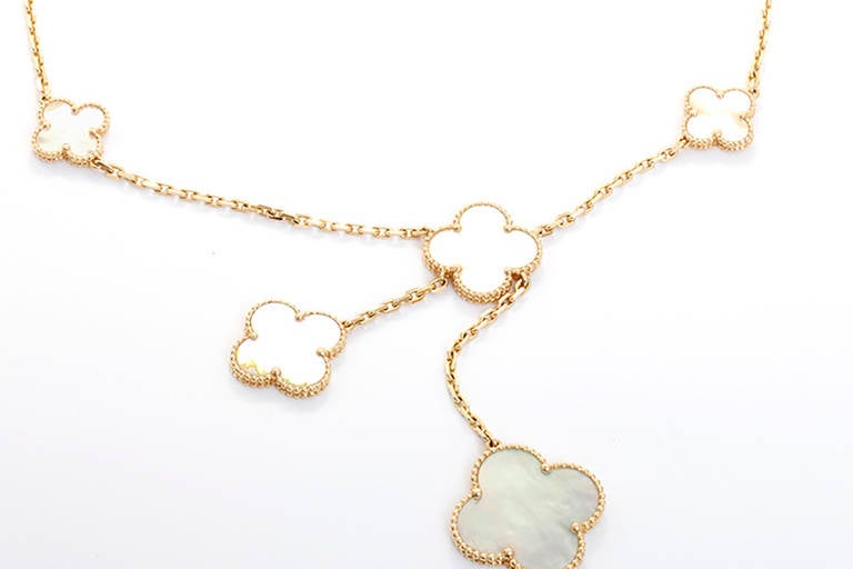 This  Van Cleef & Arpels necklace is a part of the Magic Alhambra collection. The necklace features an asymmetrical design and iconic motifs in various sizes. The pendants are mother of pearl with yellow gold contours. It is apx. 16-inches in length
