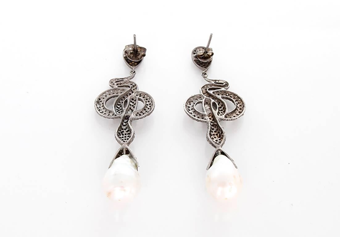 These fabulous earrings feature a coiled snake design with diamonds and baroque pearls set in oxidized silver. Earrings measure apx. 3-inches in length. Total weight is 23.3 grams.